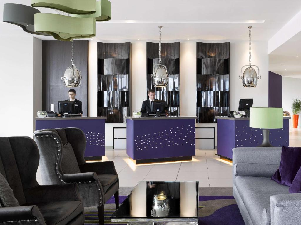 a lobby with two men sitting at a counter at Radisson Blu Waterfront Hotel, Jersey in Saint Helier Jersey