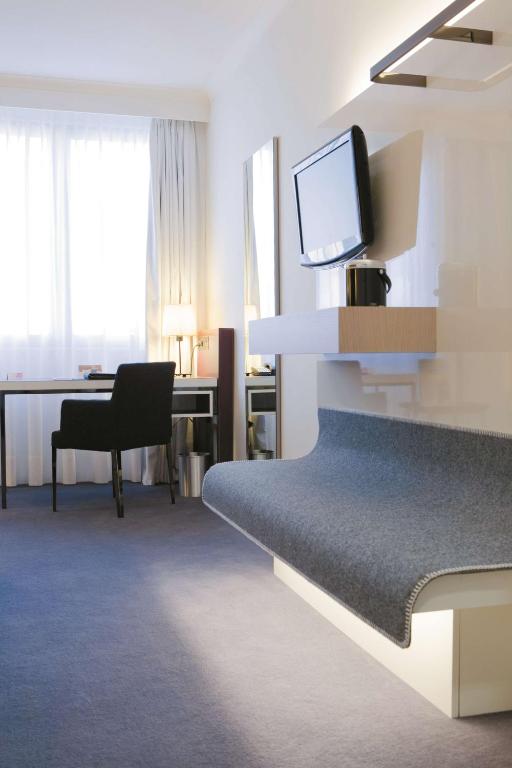a hotel room with a bed and a desk with a television at Radisson Blu Waterfront Hotel, Jersey in Saint Helier Jersey