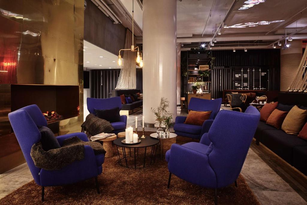 a living room with blue chairs and a table at Radisson Blu Seaside Hotel, Helsinki in Helsinki