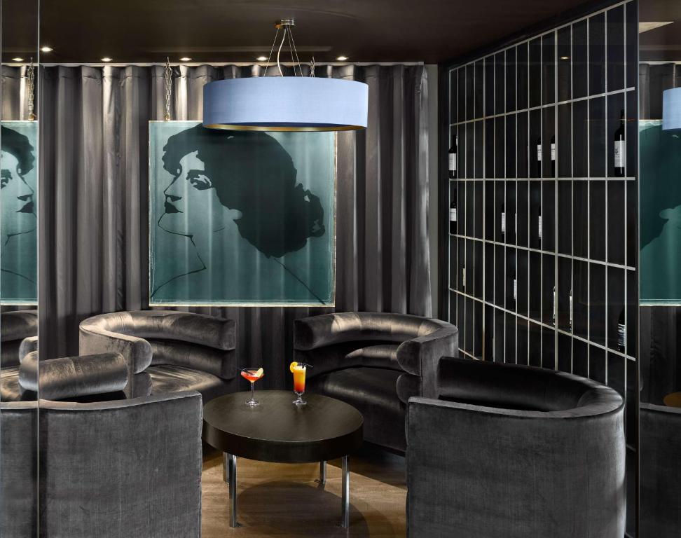 a lobby with black chairs and a table and a chandelier at Radisson Blu Waterfront Hotel, Jersey in Saint Helier Jersey