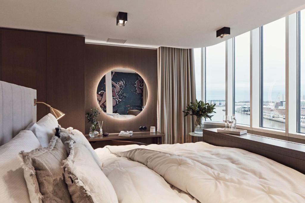 a bedroom with a large white bed with a large mirror at Radisson Blu Seaside Hotel, Helsinki in Helsinki