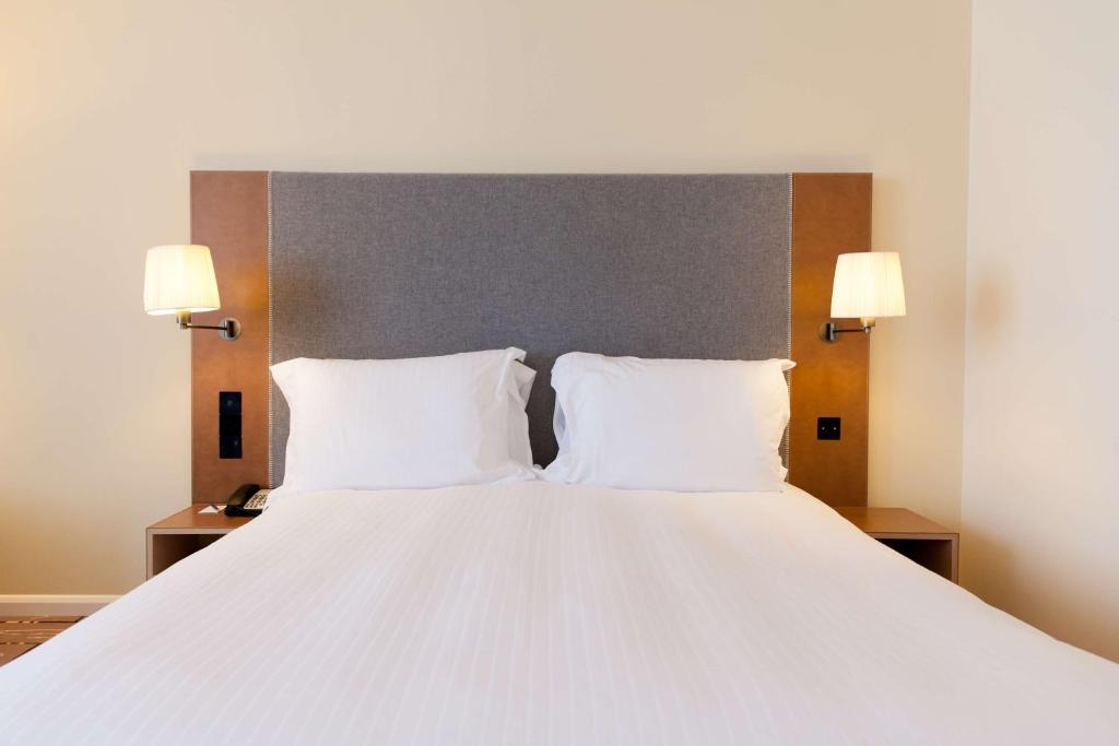 a large white bed with two pillows and two lamps at Radisson Blu Waterfront Hotel, Jersey in Saint Helier Jersey