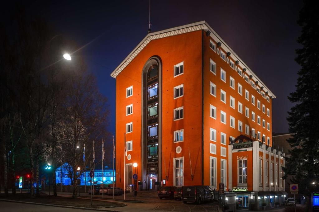 a large orange building at night at Radisson Blu Grand Hotel Tammer in Tampere