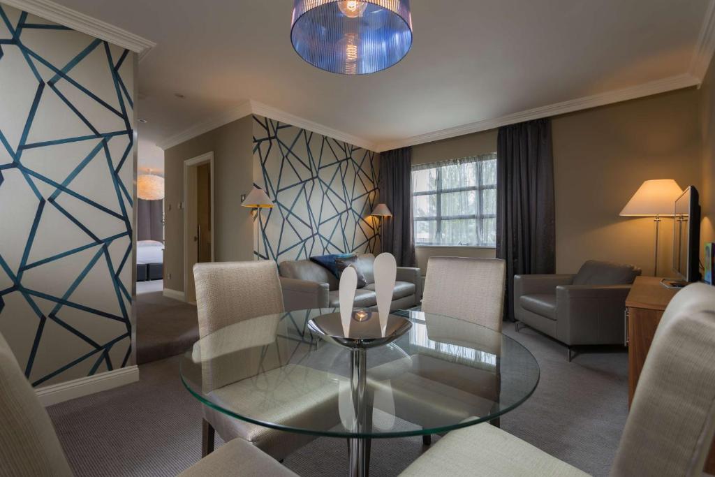 a living room with a glass table and chairs at Park Inn by Radisson Shannon Airport in Shannon