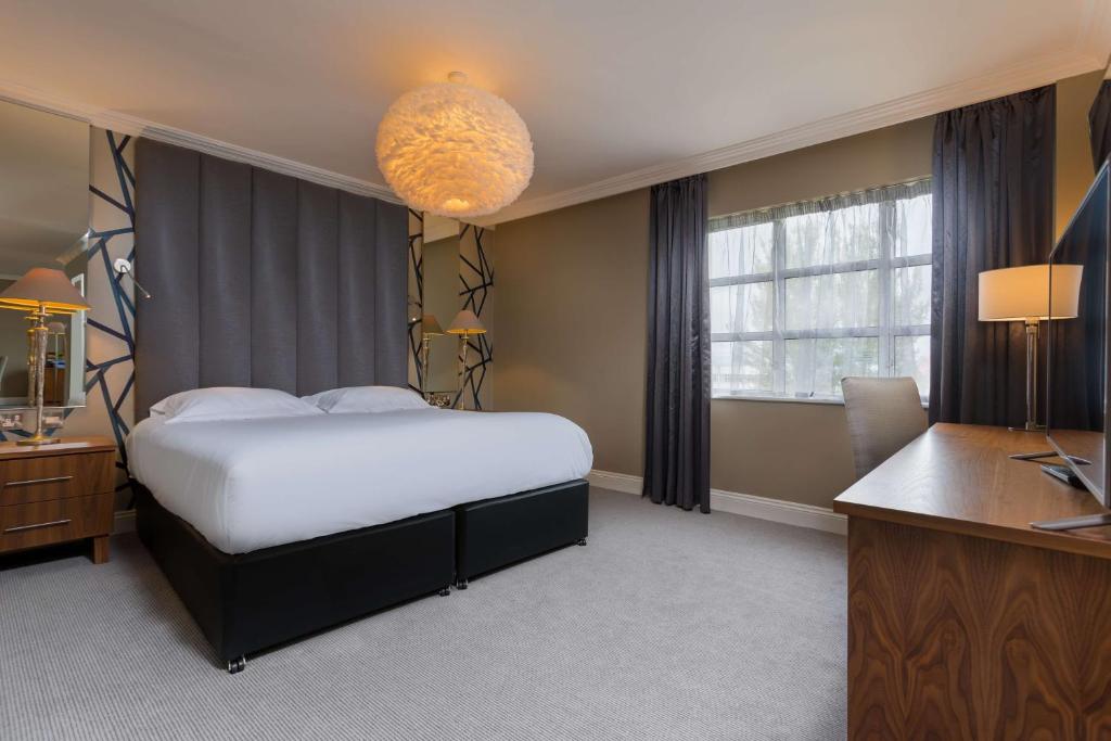 a hotel room with a bed and a desk and window at Park Inn by Radisson Shannon Airport in Shannon