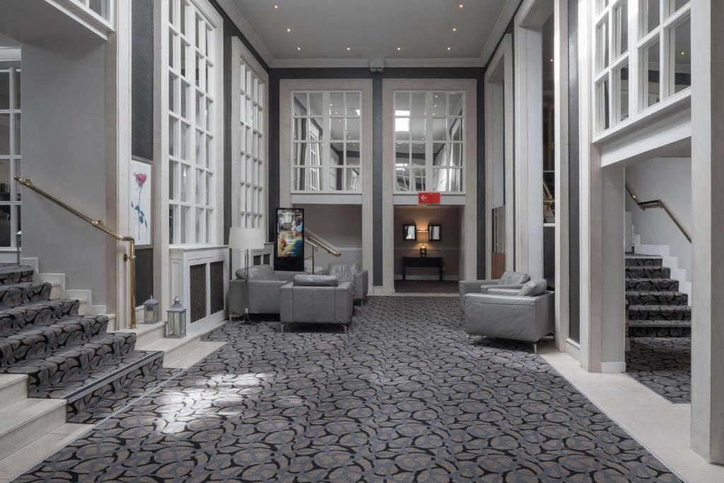 a lobby with couches and stairs in a building at Park Inn by Radisson Shannon Airport in Shannon