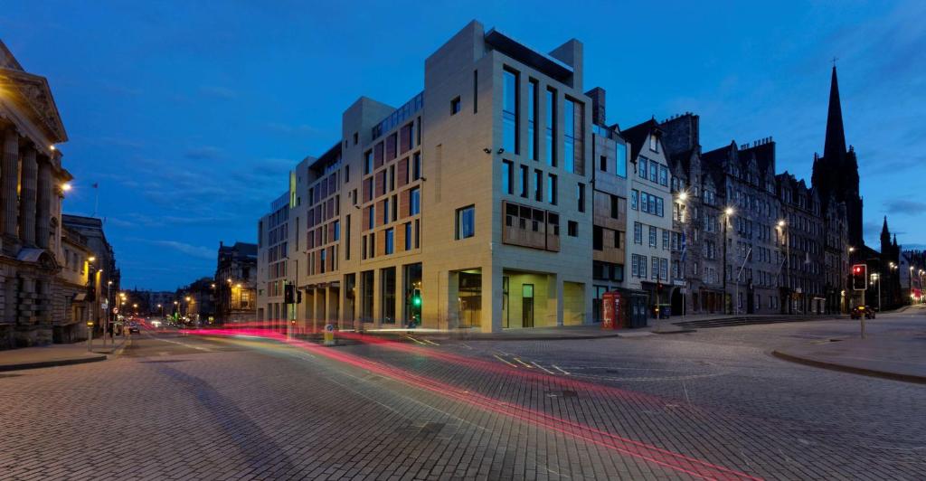 una calle de la ciudad por la noche con edificios y una iglesia en Radisson Collection Hotel, Royal Mile Edinburgh, en Edimburgo