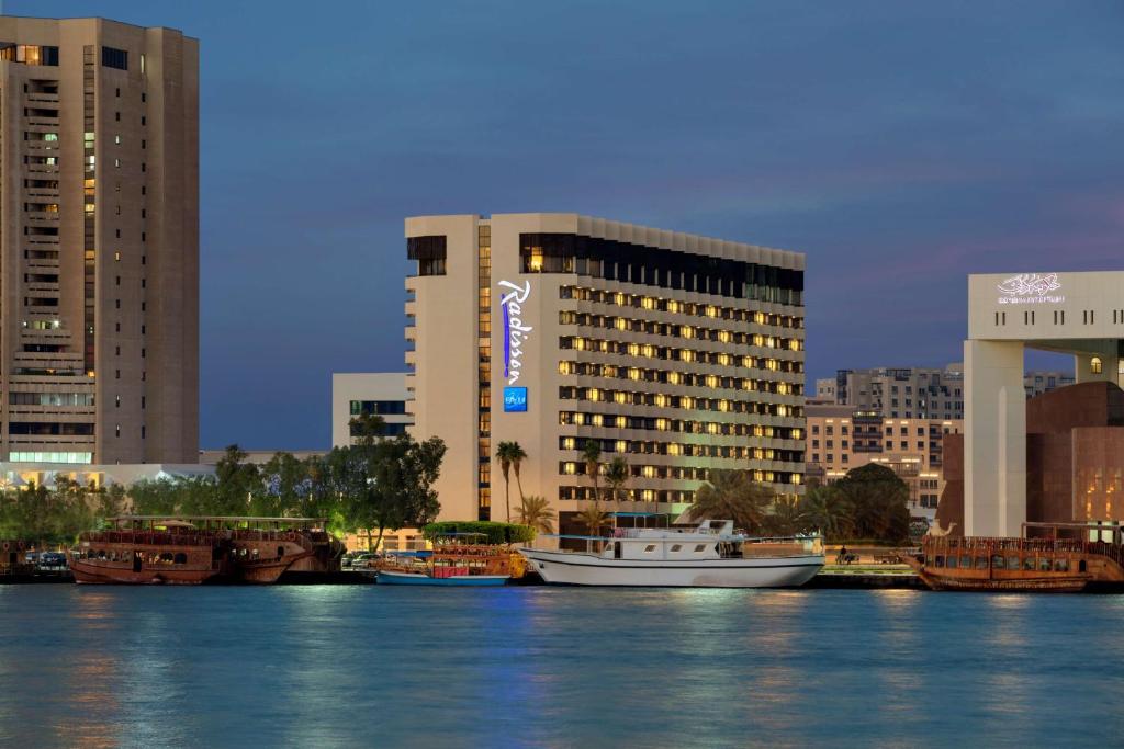 a large white boat floating on top of a body of water at Radisson Blu Hotel, Dubai Deira Creek in Dubai