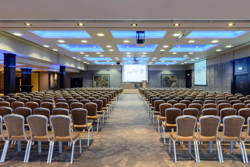 una stanza con file di sedie e uno schermo di proiezione di Radisson Blu Hotel, Athlone a Athlone