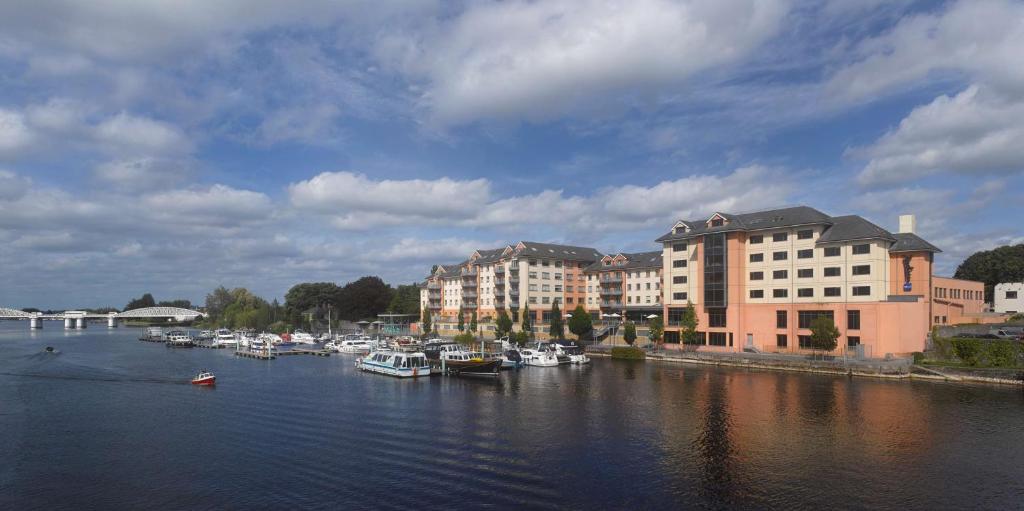 a group of boats docked in a river with buildings at Radisson Blu Hotel, Athlone in Athlone