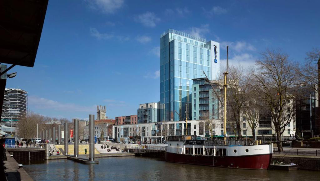 Ein Boot liegt in einem Fluss in einer Stadt. in der Unterkunft Radisson Blu Hotel, Bristol in Bristol