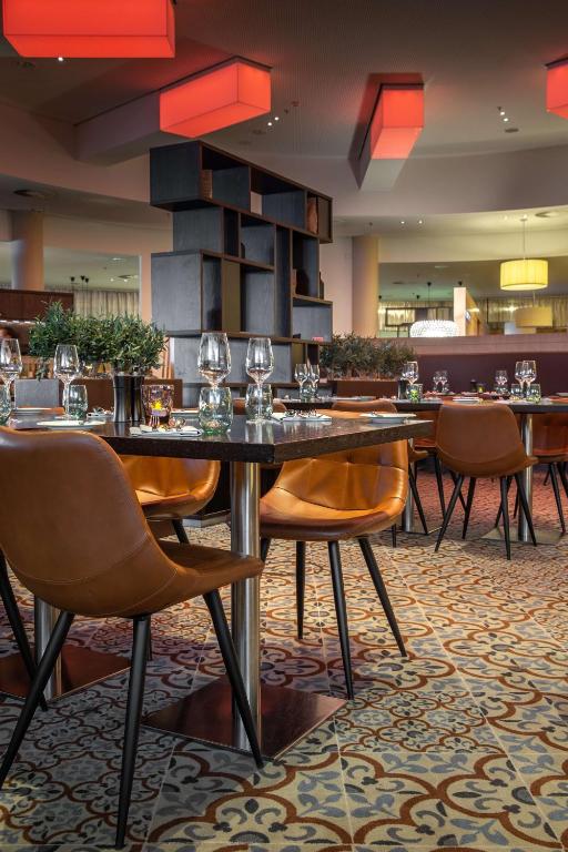 a dining room with a large table and chairs at Radisson Blu Hotel, Hamburg Airport in Hamburg