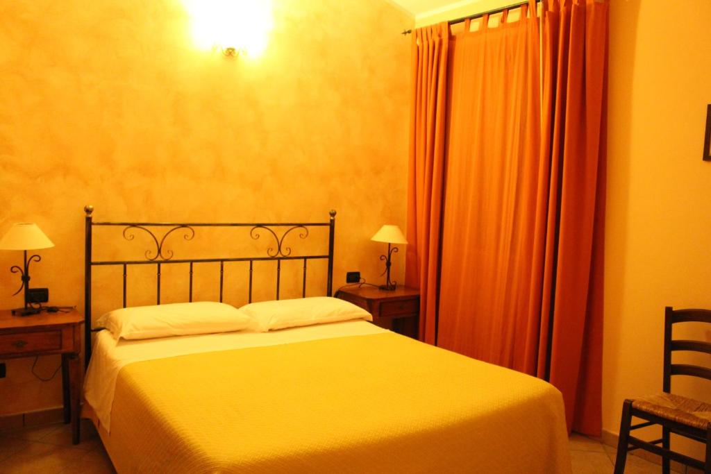 ein Schlafzimmer mit einem Bett, zwei Tischen und zwei Lampen in der Unterkunft Angelucci Agriturismo con Camere e Agri Camping in Lanciano