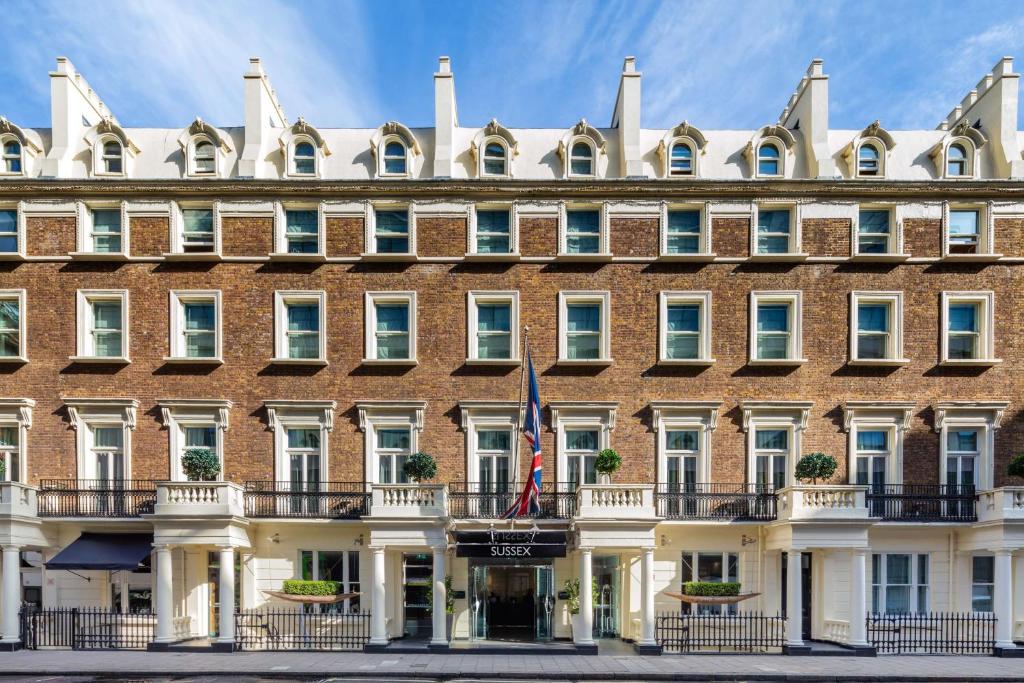 倫敦的住宿－Radisson Blu Sussex Hotel, London，前面有旗帜的大砖砌建筑