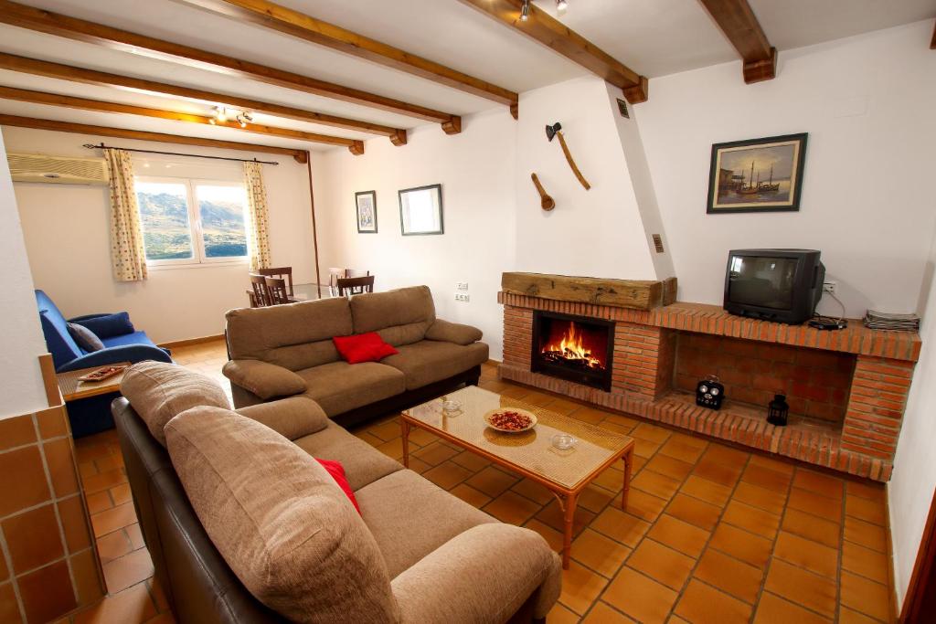 sala de estar con sofá y chimenea en casa del gastronomo, en Cortes de la Frontera