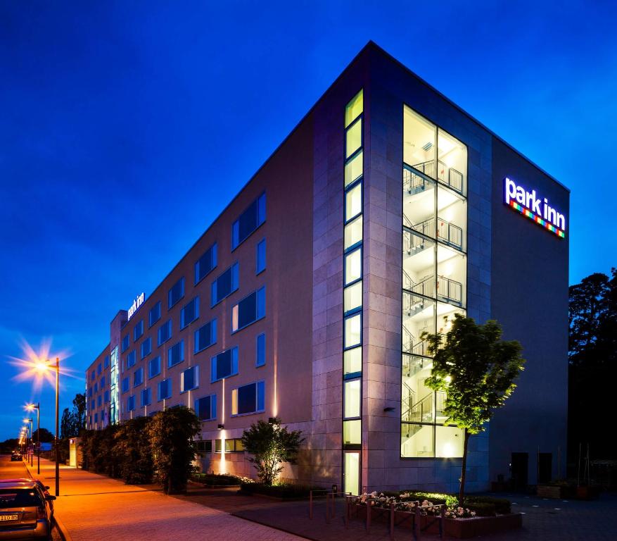 a hotel building with a lit up sign on it at Park Inn by Radisson Frankfurt Airport in Frankfurt