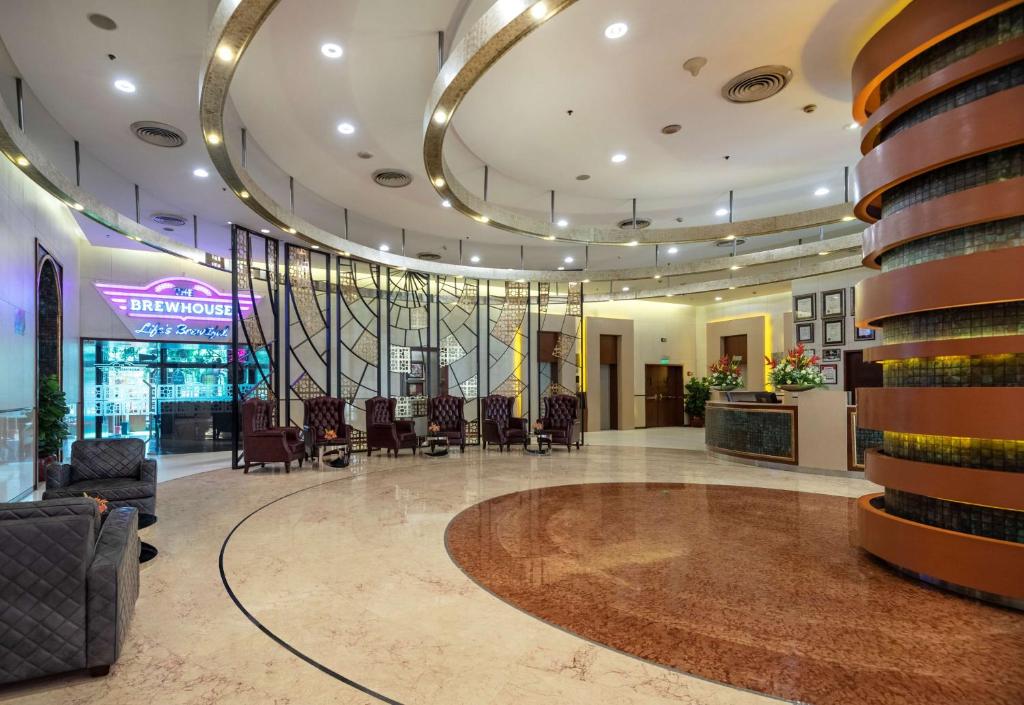 un vestíbulo de un hotel con sillas y mesa en Radisson Gurugram Sohna Road City Center, en Gurgaon