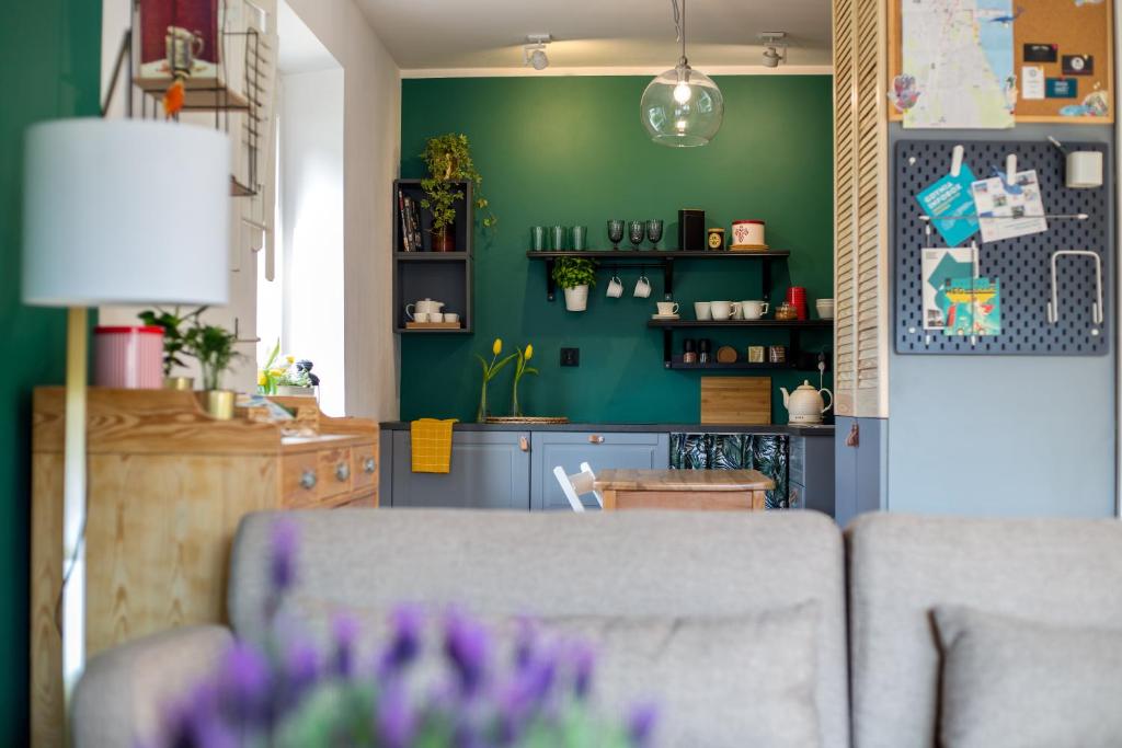 uma sala de estar com um sofá e uma parede verde em SeaFolks Apartments em Gdynia