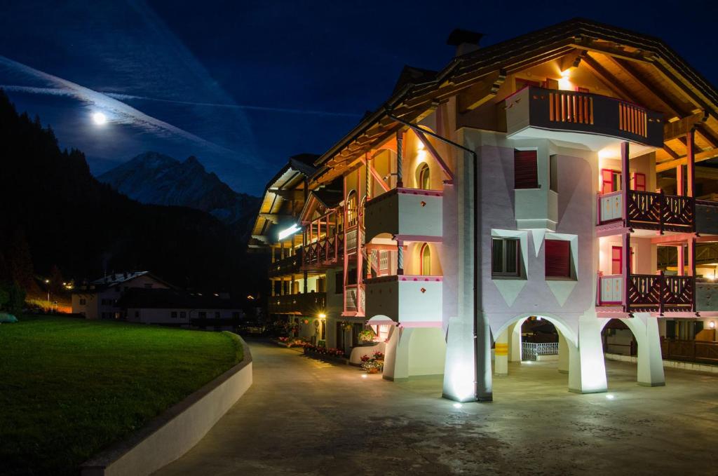 a building at night with a moon in the sky at B&B Cèsa Planber Mountain View in Canazei