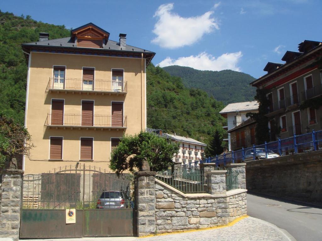 un edificio con un árbol delante en Apartamentos Valles, en Broto