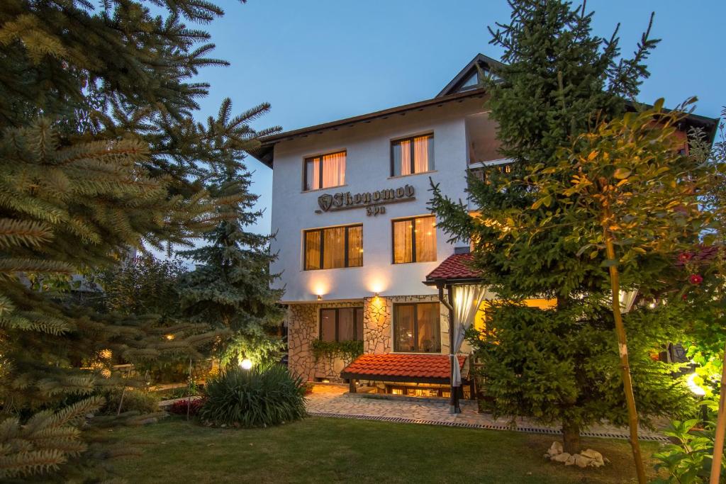 ein Gebäude mit einer Bank davor in der Unterkunft Boutique Guest House IKONOMOV in Bansko