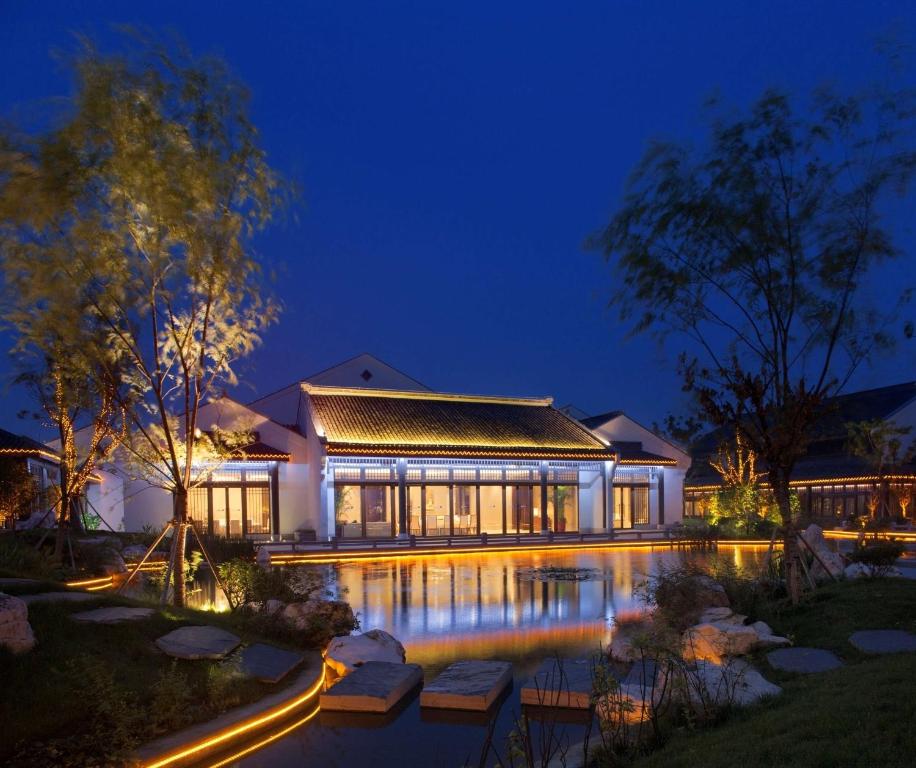 a house with a swimming pool at night at Radisson Blu Resort Wetland Park in Wuxi