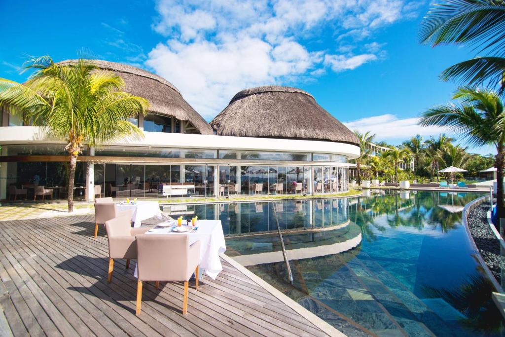 a resort with a pool and a table and chairs at Radisson Blu Poste Lafayette Resort & Spa (Adults Only) in Poste Lafayette