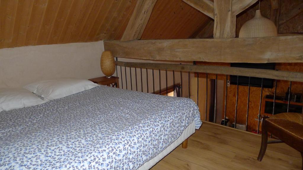 a bedroom with a bed and a wooden floor at gîte de la Cabotte in Bussy-le-Grand