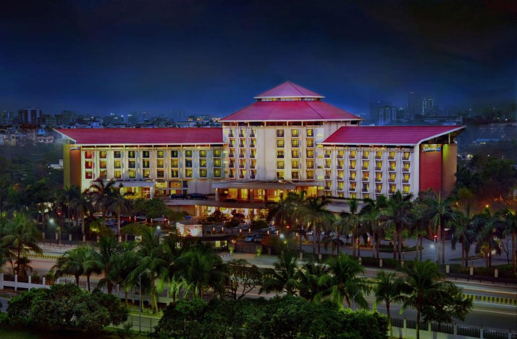 a large building with a red roof at night at Radisson Blu Dhaka Water Garden in Dhaka