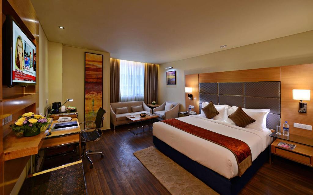 a hotel room with a large bed and a desk at Country Inn Panjim Goa in Panaji