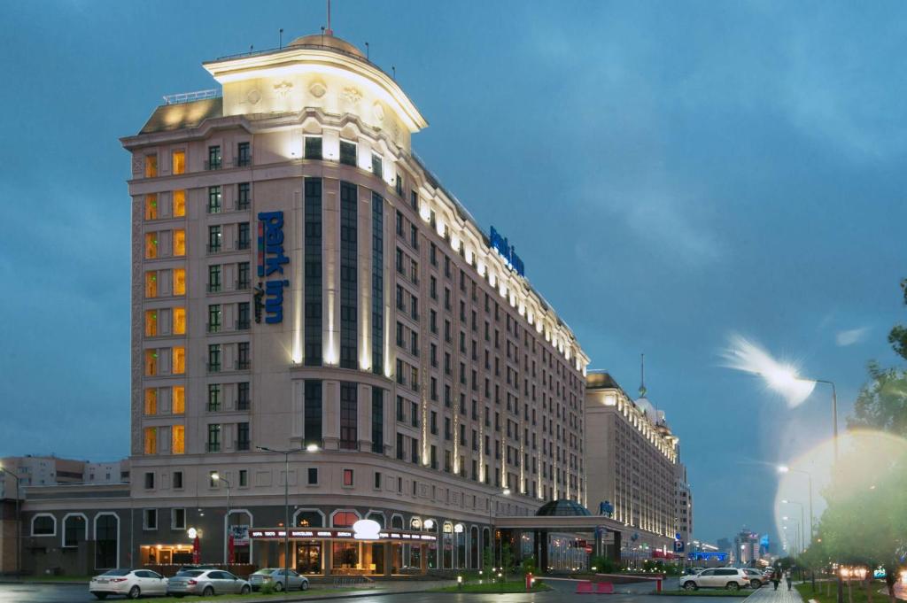 un gran edificio con un reloj encima en Park Inn by Radisson Hotel Astana, en Astana