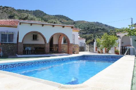 a large swimming pool in front of a house at Villa Marín in Canillas de Aceituno