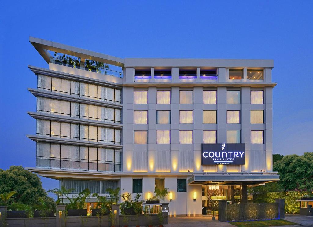 a building with a sign that reads country hotel at Country Inns & Suites By Radisson Manipal in Manipala