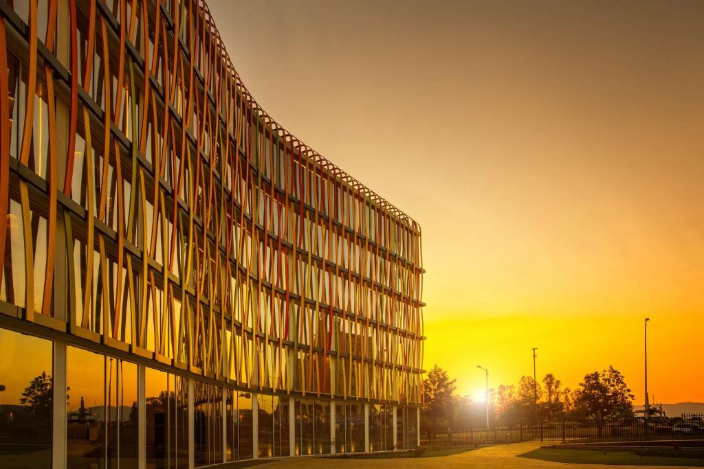 an office building with the sunset in the background at Radisson Blu Hotel & Convention Centre Kigali in Kigali
