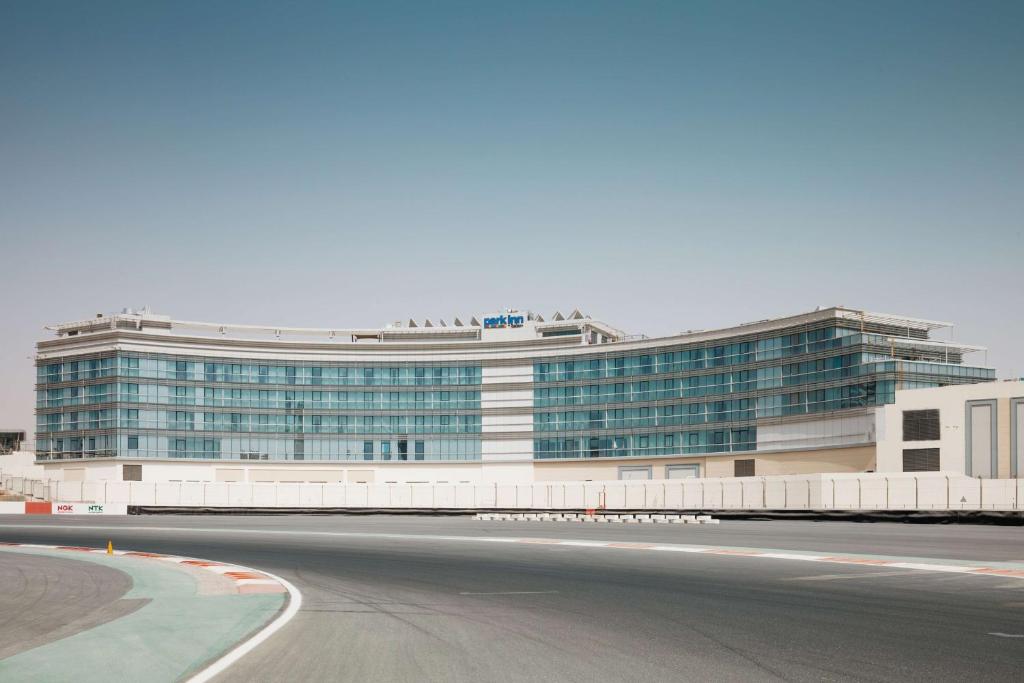 un grand bâtiment avec une route devant lui dans l'établissement Park Inn by Radisson Dubai Motor City, à Dubaï