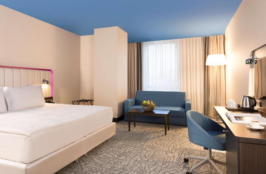 イスタンブールにあるPark Inn by Radisson Istanbul Atasehirのベッドとデスクが備わるホテルルームです。
