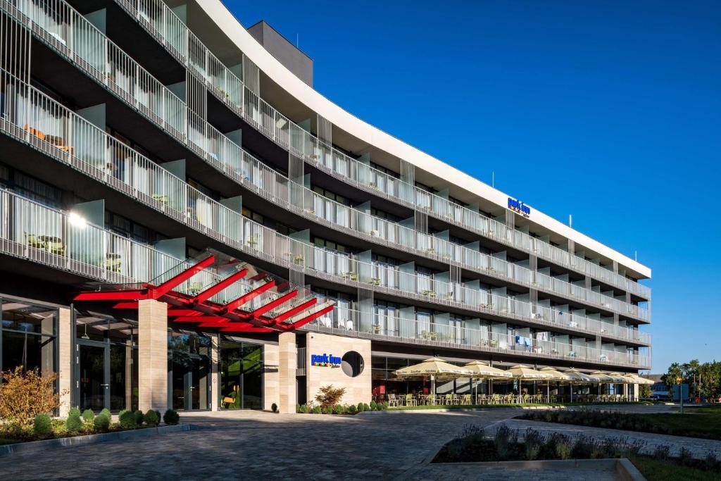 an external view of a building with a red structure at Park Inn By Radisson Zalakaros Hotel & Spa in Zalakaros