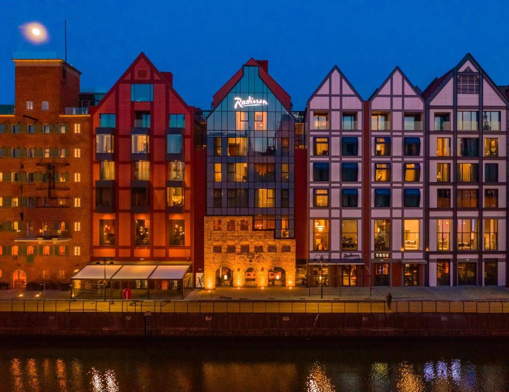 グダニスクにあるRadisson Hotel & Suites, Gdansk, Wyspa Spichrzówの川の横の色彩豊かな建物