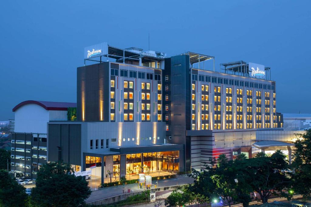 a large building with lights on in a city at Radisson Lampung Kedaton in Bandar Lampung