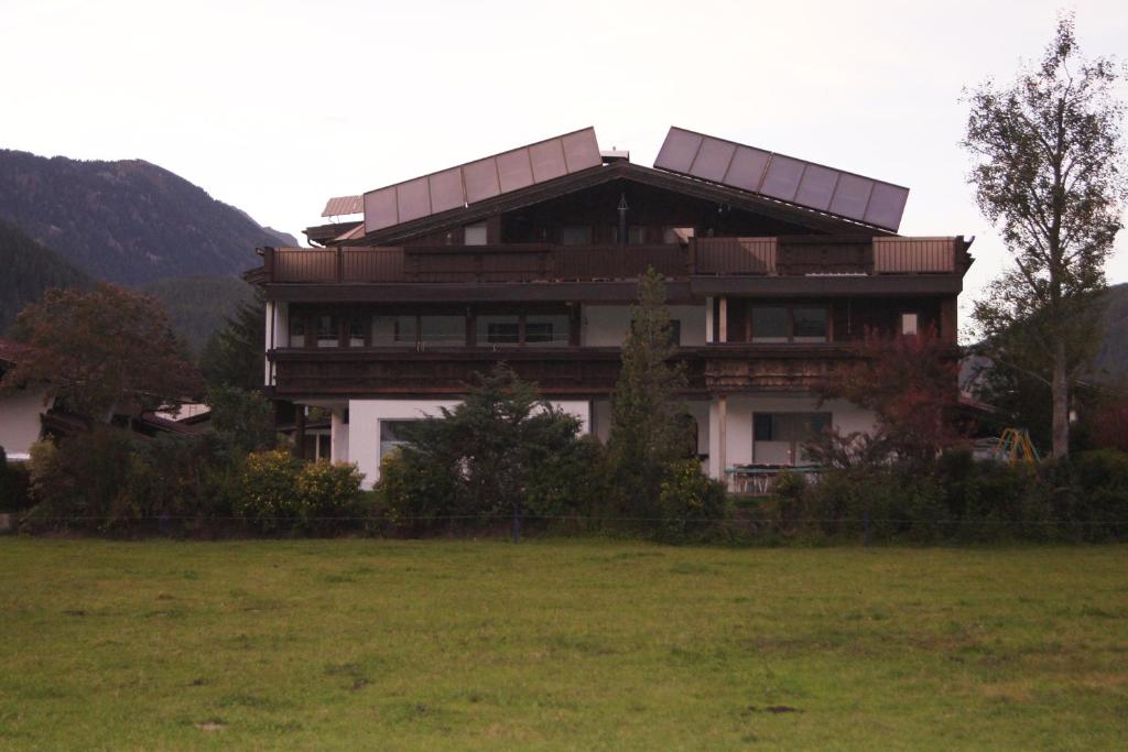 a large house with a field in front of it at Familienferienhaus Florentine in Längenfeld