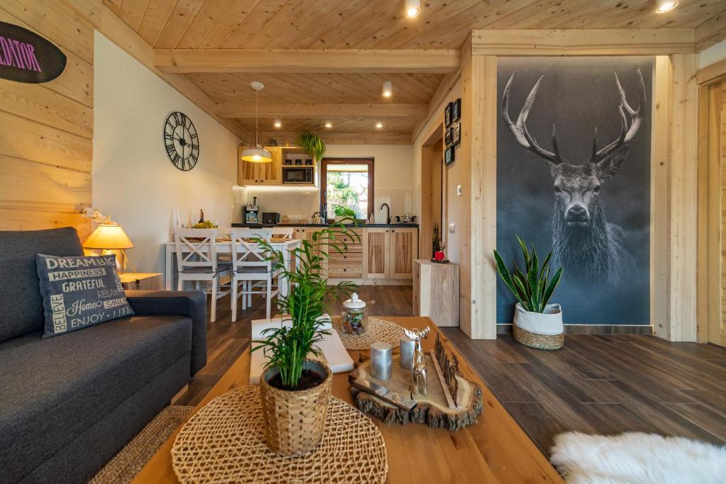 una sala de estar con sofá y una pintura de ciervos en la pared en Apartament Leśny en Zakopane