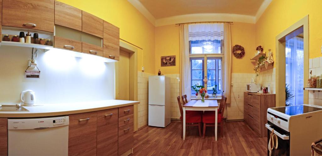 kuchnia ze stołem i białą lodówką w obiekcie Apartmán pod rozhlednou w mieście Roudnice nad Labem
