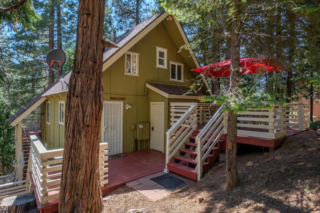 a tree house with a deck in the woods at Yosemite Hideaway A in Yosemite West