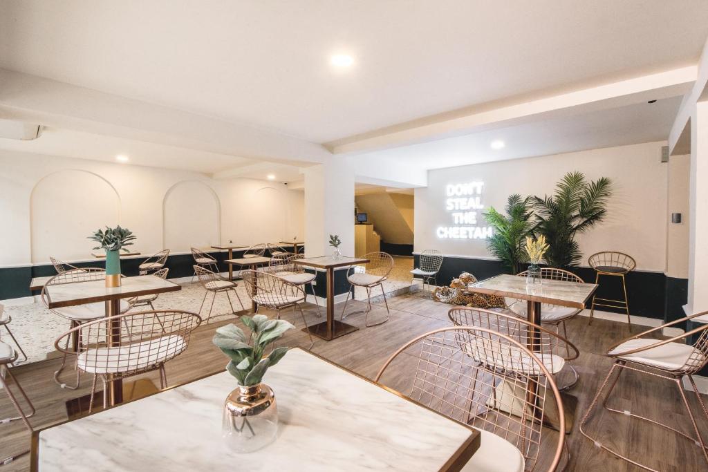 a restaurant with tables and chairs in a room at Theme Boutique Hotel Bangkok in Bangkok