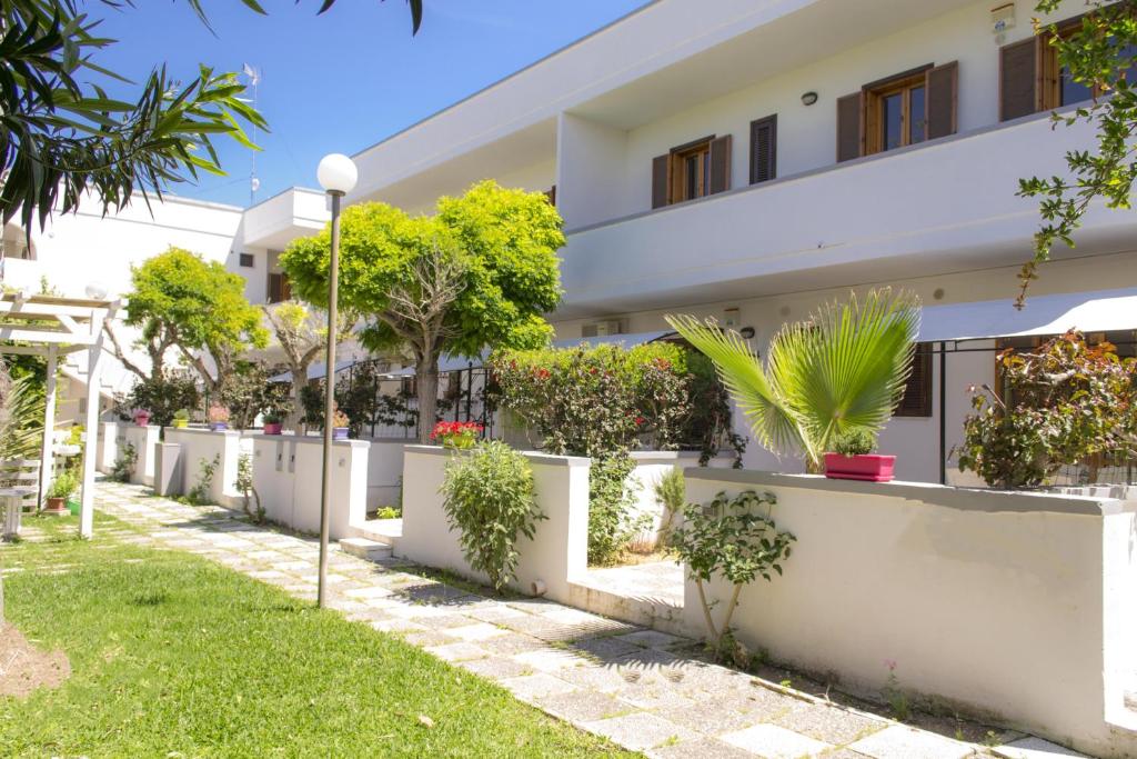 a white building with plants in the yard at Residence Borgo Latino- Localo in Torre dell'Orso