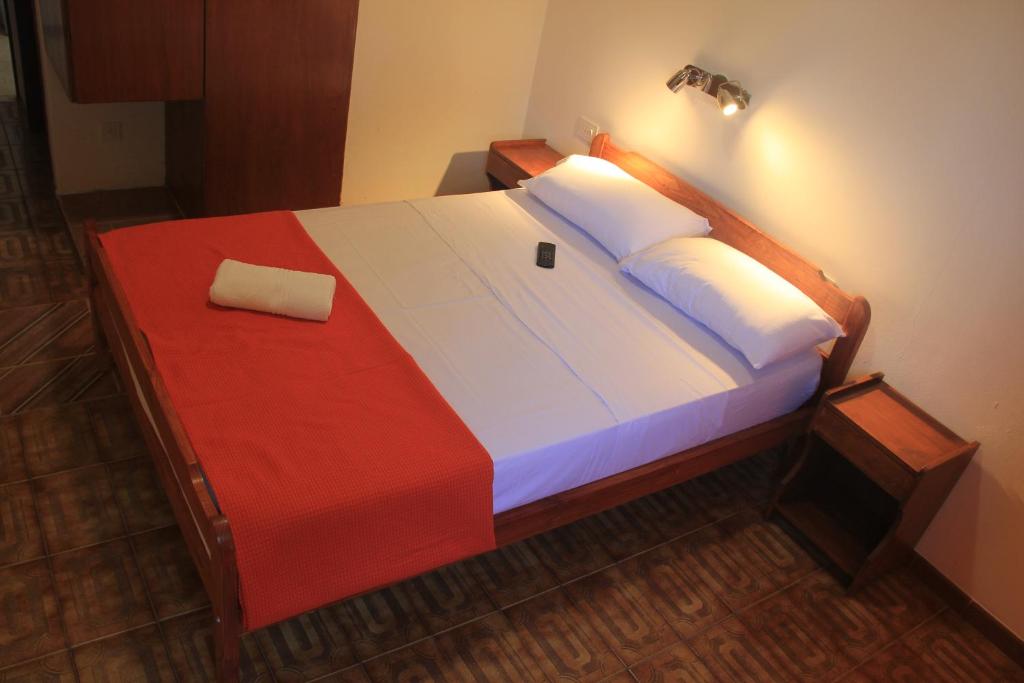 a bedroom with a large bed with a red and white blanket at Hotel Vanderloo in Posadas