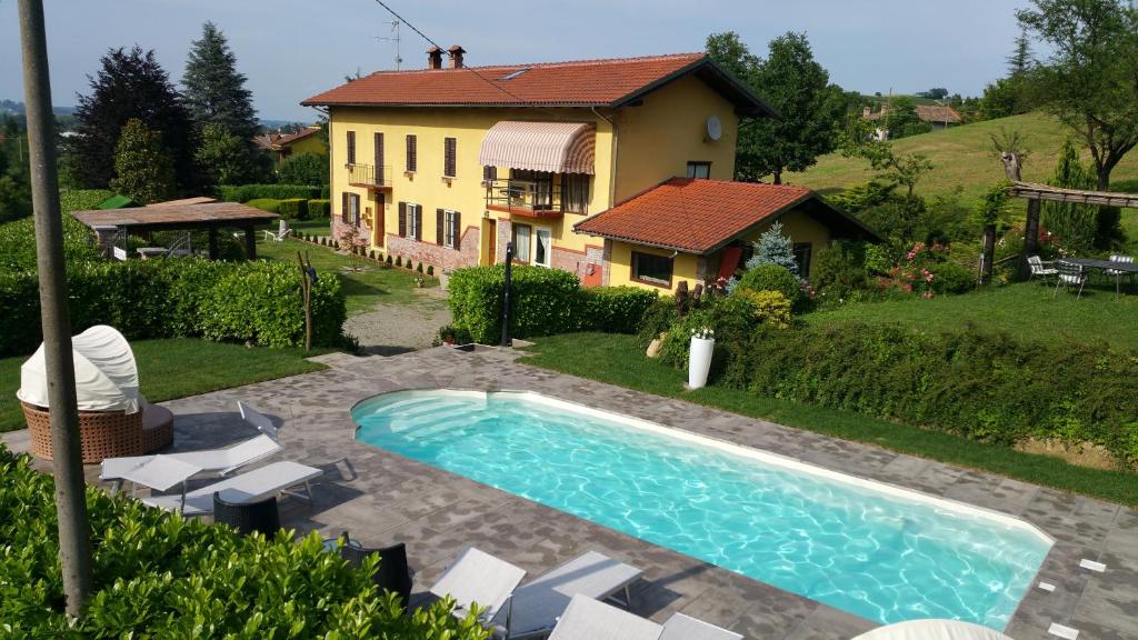 uma casa com piscina em frente a uma casa em Bed & Bistrò Che Piasì em Calamandrana