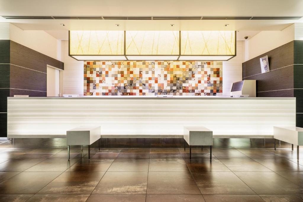 a bar in a restaurant with two chairs at Sotetsu Fresa Inn Higashi Shinjuku in Tokyo
