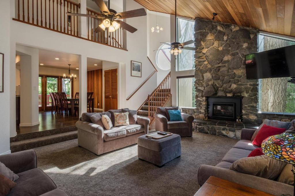 a living room with couches and a stone fireplace at Yosemite Magic "A" in Yosemite West