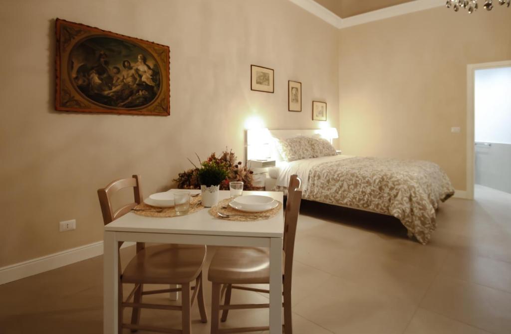 a bedroom with a bed and a table with chairs at Dimora Porta Garibaldi in Catania